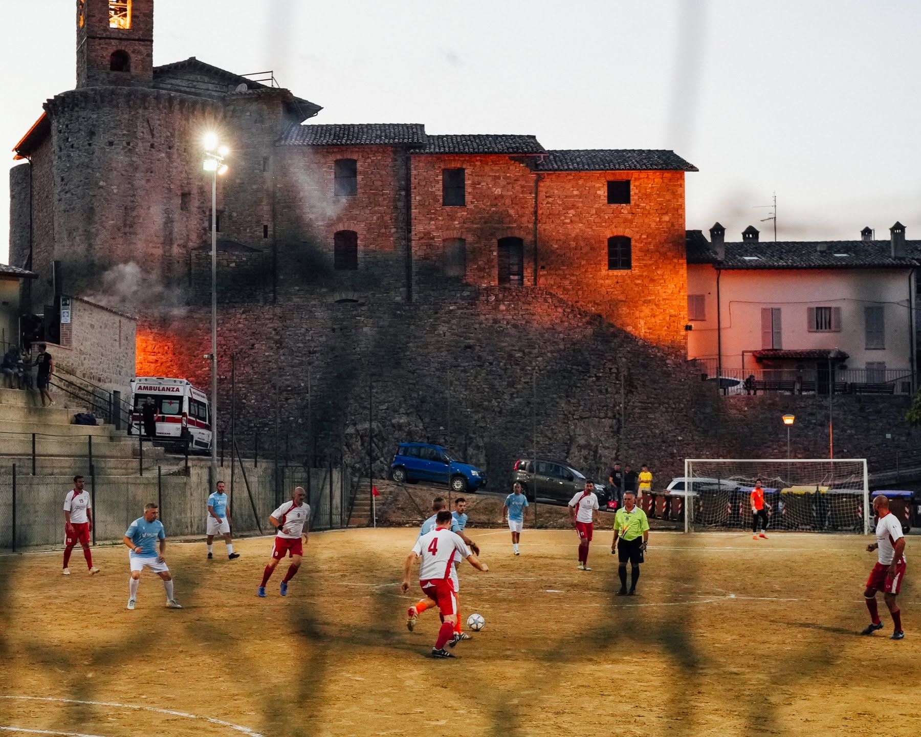 Partita di calcetto serale con il borgo sullo sfondo