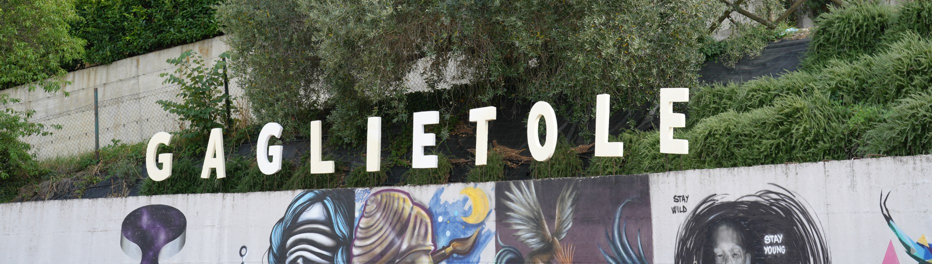 Insegna di Gaglietole con i murales sottostanti