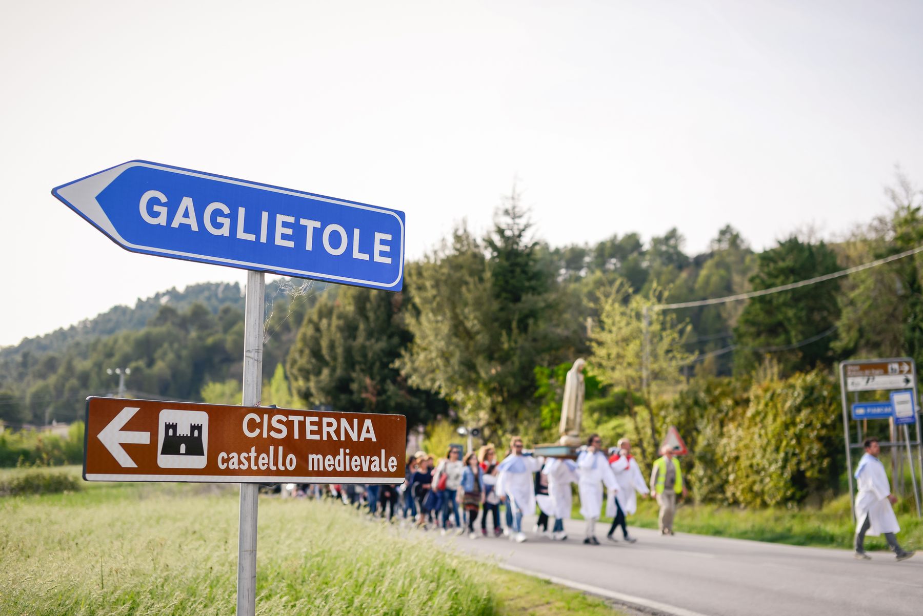 Il cartello di Gaglietole con la processione sullo sfondo