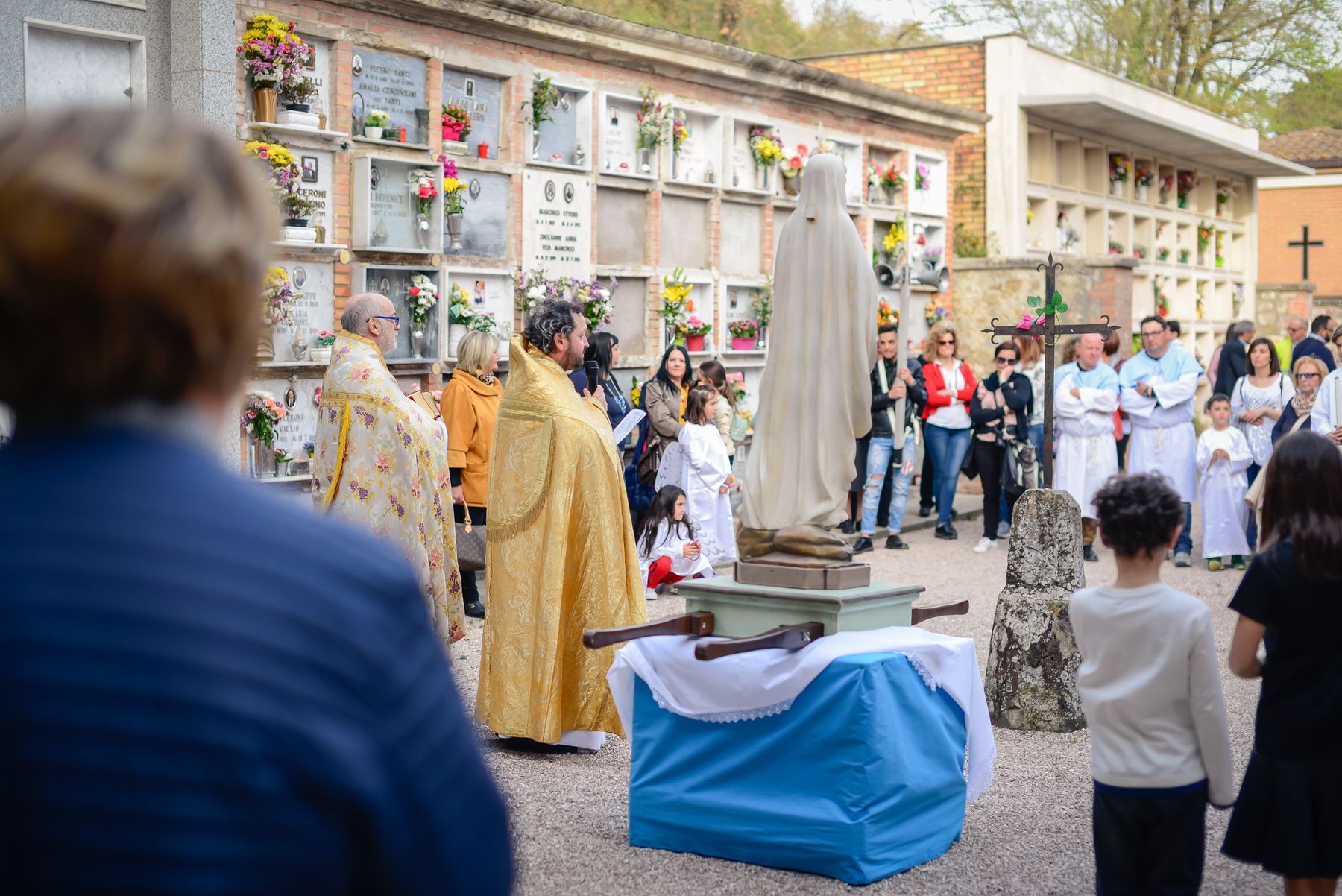 Il sacerdote benedice la statua della Madonna al cimitero