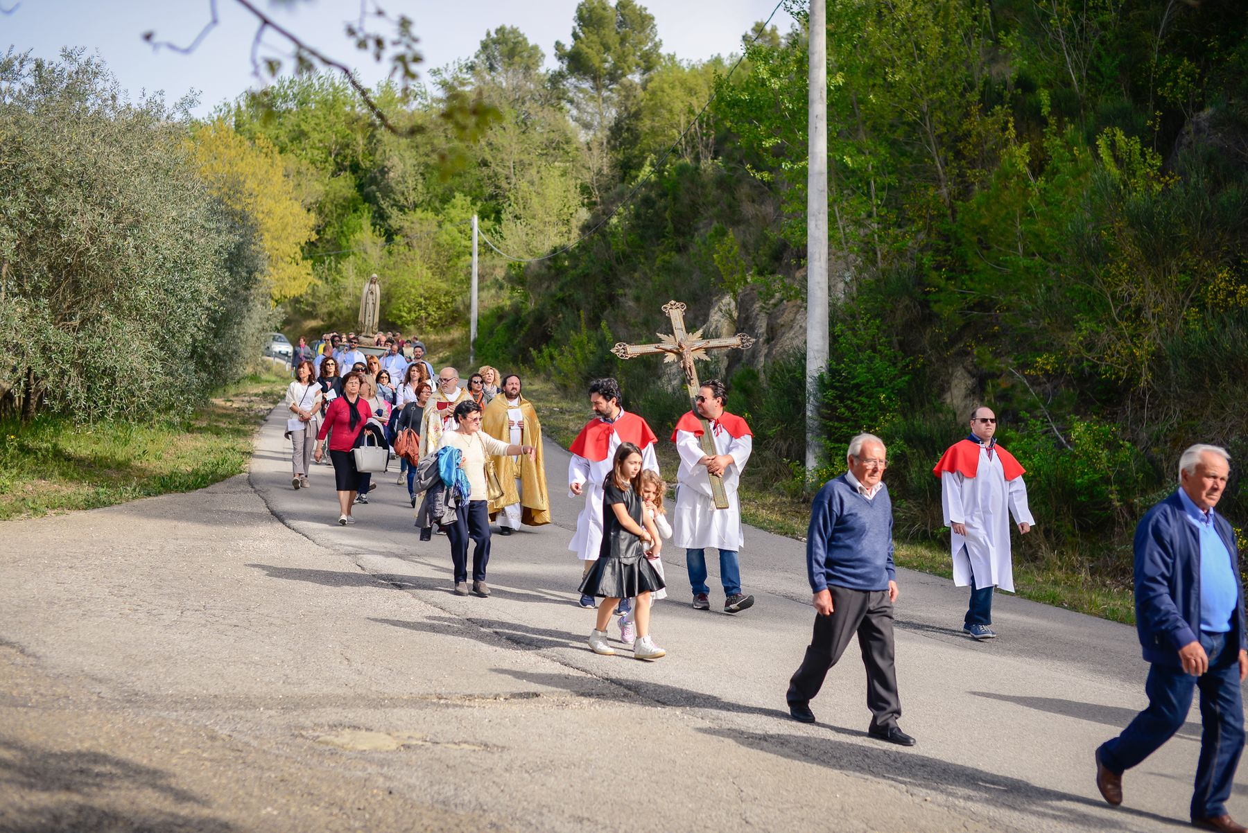 Corteo della processione con la croce e il sacerdote in paramenti dorati